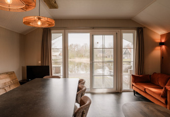 Salon moderne dans un lodge de groupe au parc de vacances Eigen Wijze, Pays-Bas, surplombant le lac.