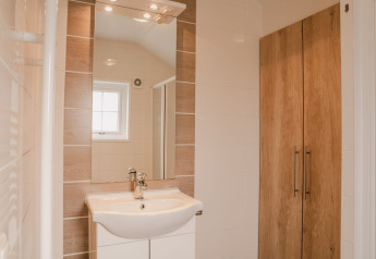 Modern bathroom interior at Group lodge, Holiday park Eigen Wijze, with sink, mirror, and wooden cabinet.