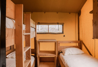 Interieur van een glampingtent met stapelbed en eenpersoonsbed bij Holiday park Eigen Wijze, Nederland.