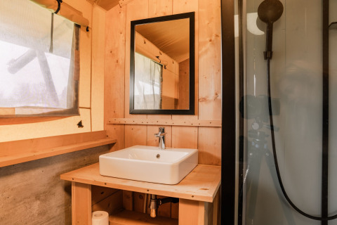 Badkamer in een glampingtent bij Holiday park Eigen Wijze in Nederland met wastafel en spiegel.