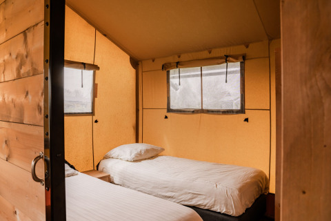 Innenansicht eines Glamping-Zeltes mit zwei Einzelbetten im Holiday Park Eigen Wijze in den Niederlanden.