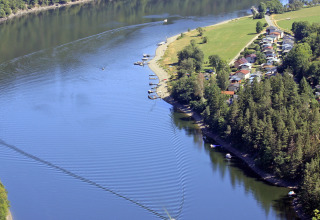 Aerial view of BoerenBed Hohenwarter Seehof holiday park by the lakeshore in Thuringia, Germany, with boats.