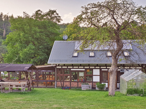 Hyggeligt bindingsværkshus med glashus og have ved BoerenBed Hohenwarter Seehof i Thüringen, Tyskland.