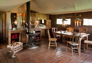 Rustikales Hütteninnere mit Holzofen, Holzmöbeln und gemütlichem Essbereich im Hohenwarter Seehof, Thüringen.