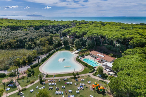 Luftfoto af Sandaya Etruria feriepark i Toscana, Italien, med pool, grønne træer og udsigt til havet.