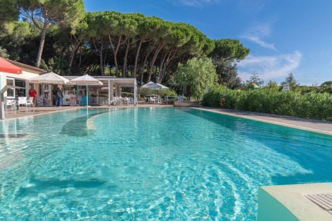Parque vacacional Sandaya Etruria en la Toscana, Italia, con piscina, cafetería y pinos al fondo.