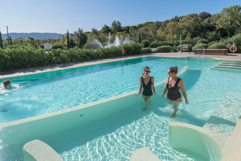 Due donne si rilassano nella piscina del villaggio turistico Sandaya Etruria in Toscana, Italia.