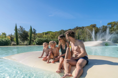 Famiglia che si gode una giornata di sole in piscina al Sandaya Etruria, villaggio vacanze in Toscana, Italia.