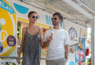 Ein junges Paar genießt Eis an einem Stand im Ferienpark Sandaya Etruria in der Toskana, Italien.