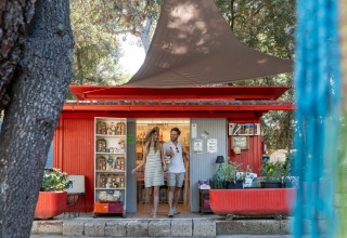 Pareja sale de una tienda roja en Sandaya Etruria, un parque vacacional en la Toscana, Italia.