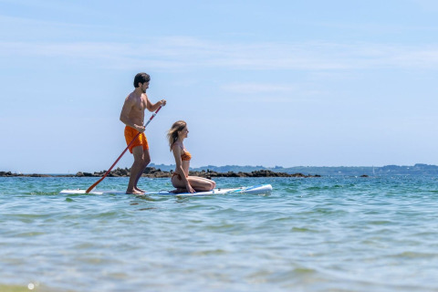 Koppel geniet van stand up paddleboarden op zee bij Sandaya Etruria vakantiepark in Toscane, Italië.