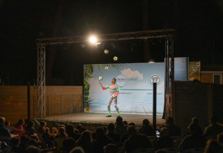 A juggler performs on an outdoor stage at night at Sandaya Etruria holiday park in Tuscany, Italy.