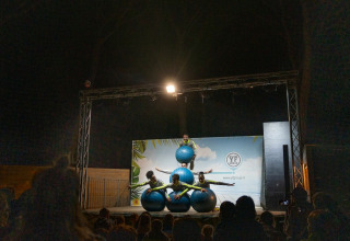 Performers balance on blue balls during a nighttime show at Sandaya Etruria holiday park in Tuscany, Italy.
