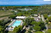 Luchtfoto van Sandaya Toscana Bella vakantiepark in Toscane, Italië, met zwembad en zeezicht.
