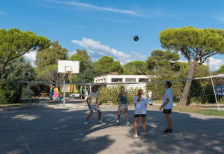 Four people play volleyball on an outdoor court at Sandaya Toscana Bella holiday park in Tuscany, Italy.