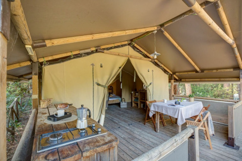 Interior de la tienda safari Tent Kenya en Sandaya Etruria en Italia, con zona de cocina y comedor.