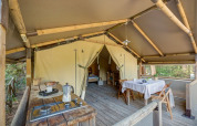 Interior de la tienda safari Tent Kenya en Sandaya Etruria en Italia, con zona de cocina y comedor.