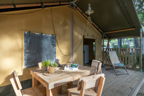Buiten eetruimte bij de safaritent Country Lodge op Sandaya Etruria in Italië, met houten meubelen.