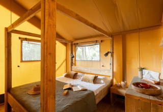 Indretning af et komfortabelt soveværelse i et safaritelt på Country Lodge, Sandaya Etruria, Italien.