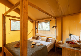 Habitación acogedora en una tienda safari de Country Lodge, Sandaya Etruria, Italia, con detalles de madera.