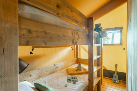 Hyggeligt soveværelse med køjeseng i safari teltet Country Lodge på Sandaya Etruria, Italien.