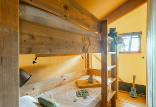 Hyggeligt soveværelse med køjeseng i safari teltet Country Lodge på Sandaya Etruria, Italien.