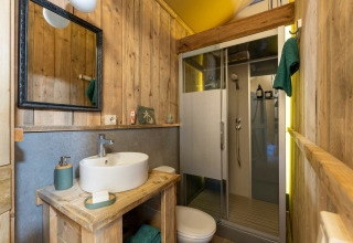 Badezimmer im Country Lodge Safari-Zelt bei Sandaya Etruria, Italien, mit Holzwänden und moderner Dusche.