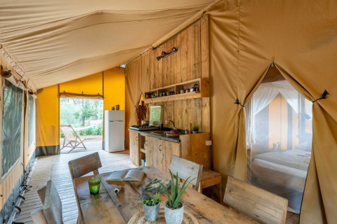 Foto interior de una tienda safari en Country Lodge Large, Sandaya Etruria, Italia, con muebles de madera.