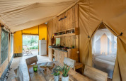Interior photo of a safari tent at Country Lodge Large, Sandaya Etruria, Italy, featuring wood furniture.