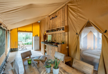 Foto interior de una tienda safari en Country Lodge Large, Sandaya Etruria, Italia, con muebles de madera.