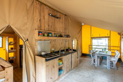 Indretning af et rummeligt teltkøkken og spiseplads i Country Lodge Large på Sandaya Etruria i Italien.