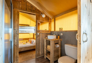 Landlig safari-telt Country Lodge Large på Sandaya Etruria, Italien, med træmøbler og privat bad.