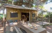 Safari tent Lodge Oasi met houten terras en picknicktafel bij Sandaya Etruria camping in Italië.
