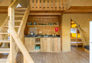 Indvendig udsigt til Lodge Oasi safari-telt på Sandaya Etruria i Italien med køkken og hems.