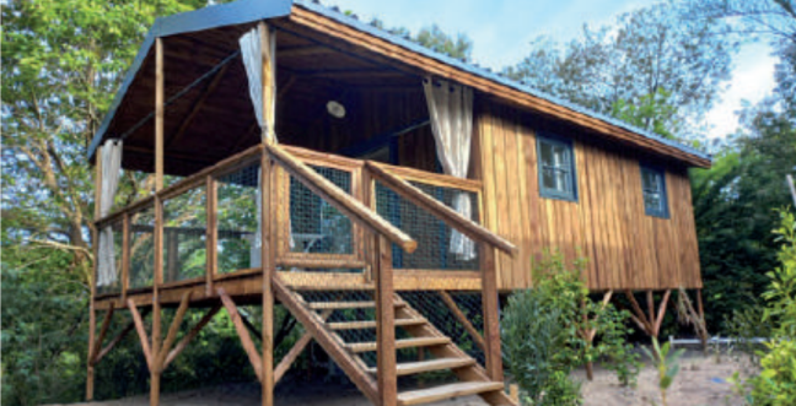 Houten hut met veranda en trap bij Minca cabin Jacuzzi & Valley View op Camping Domaine de la Faurie, Frankrijk.
