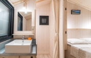 Bright and modern interior with a sink and bedroom in Minca cabin Jacuzzi & Valley View, Camping Domaine de la Faurie.