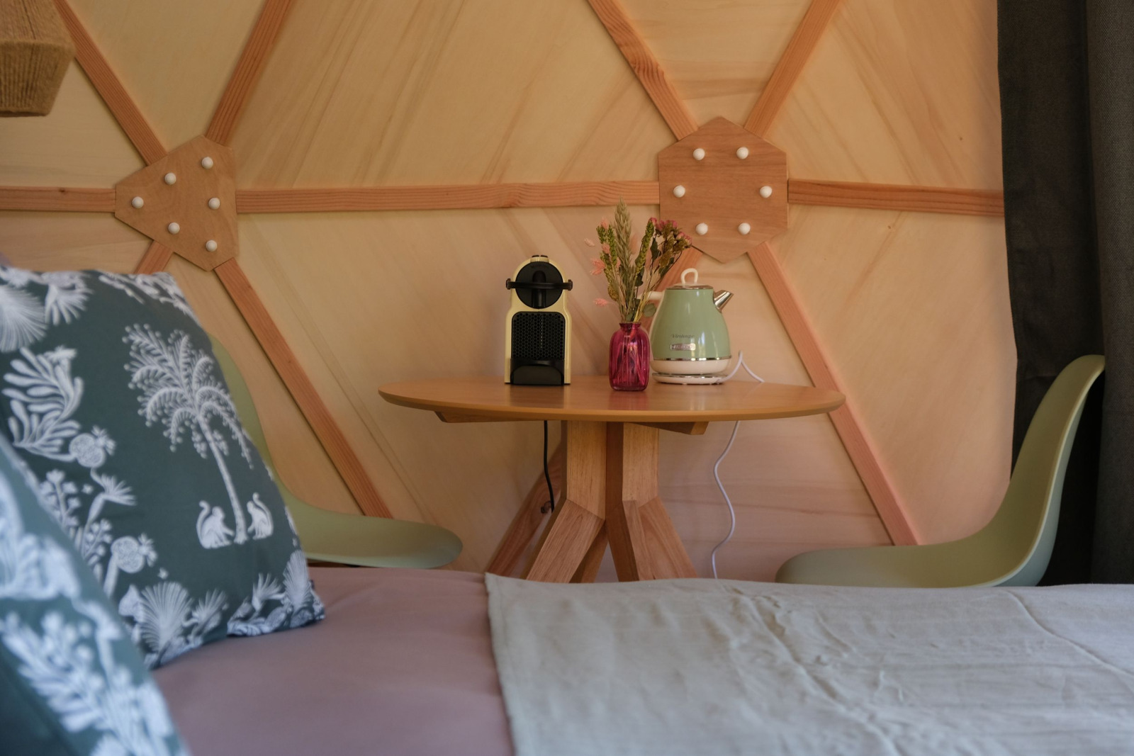 Interieur van Skydome Ushuaïa bij Camping Domaine de la Faurie, Frankrijk, met tafel, stoelen en kussens.