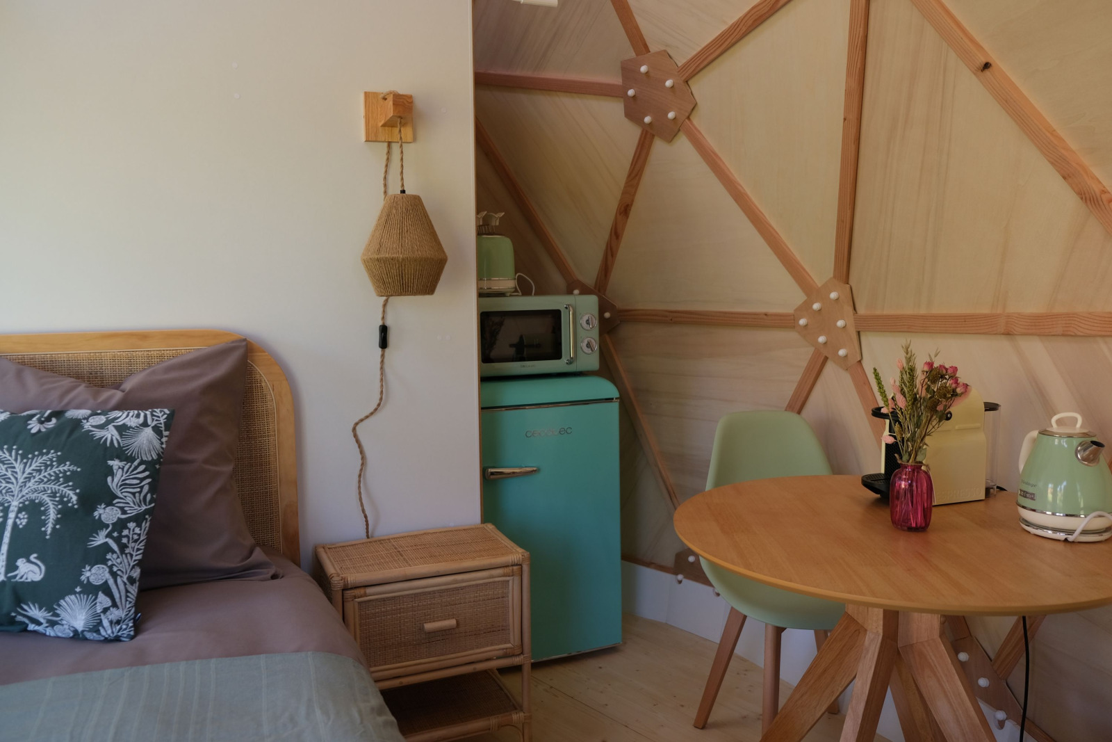 Knus koepelinterieur bij Skydome Ushuaïa met bed, eettafel, retro koelkast en kitchenette.
