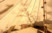 Interior de una acogedora tienda tipi con cama en Tent Nomad, Camping Domaine de la Faurie, Francia.