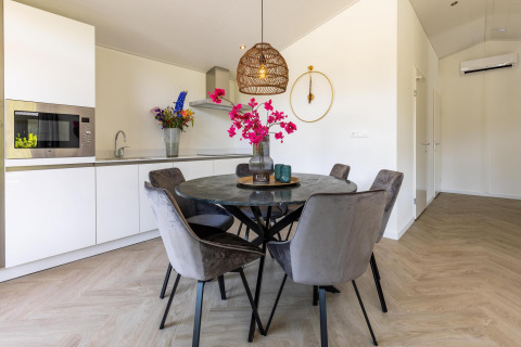 Cucina moderna e zona pranzo in Villa Waterzicht Luxe con sauna, Holiday park Molenvelden, Paesi Bassi.
