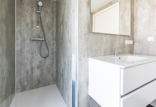 Bagno moderno con doccia e lavabo presso Villa Waterzicht Luxe met Sauna nel Holiday park Molenvelden, Paesi Bassi.