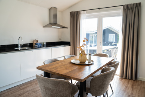 Zona pranzo e cucina moderna nella Villa Waterzicht Comfort al parco vacanze Molenvelden, Paesi Bassi.
