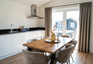 Zona pranzo e cucina moderna nella Villa Waterzicht Comfort al parco vacanze Molenvelden, Paesi Bassi.