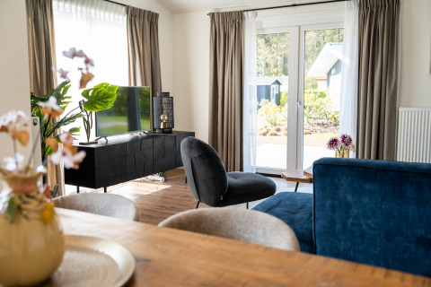 Modern living room in Villa Waterzicht Comfort with garden view at Holiday park Molenvelden, Netherlands.