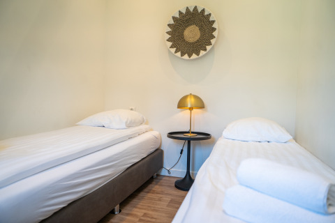 Zimmer in der Villa Waterzicht Comfort im Ferienpark Molenvelden, Niederlande, mit zwei Einzelbetten.