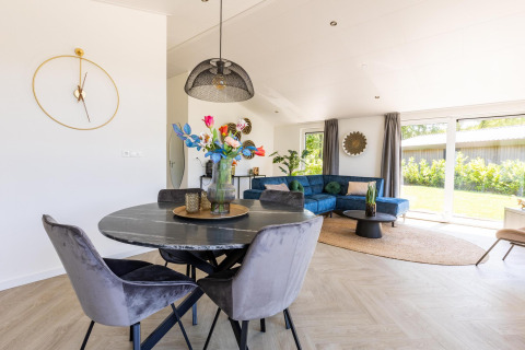 Soggiorno e sala da pranzo moderni di Villa Waterzicht Luxe 4 al Holiday park Molenvelden, Paesi Bassi.