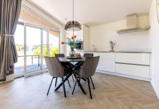 Moderne køkken og spisestue i Villa Waterzicht Luxe 4 på Holiday park Molenvelden, Nederlandene.