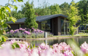 Moderne lodge aan het water tussen bloemen en bomen bij Villa Waterzicht Luxe 6, Molenvelden park.