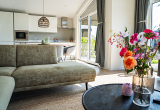 Salon lumineux et cuisine moderne à la Villa Waterzicht Luxe 6, Holiday park Molenvelden, aux Pays-Bas.