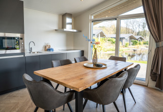 Cucina moderna e zona pranzo con vista sul laghetto presso Villa Waterzicht Luxe 6, Holiday park Molenvelden.